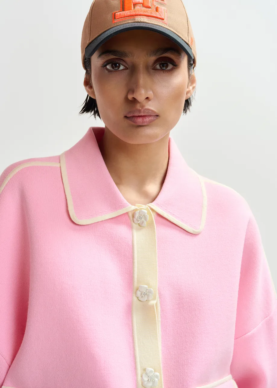 Roze cardigan met bloemetjesknopen en gebroken witte contrastboord