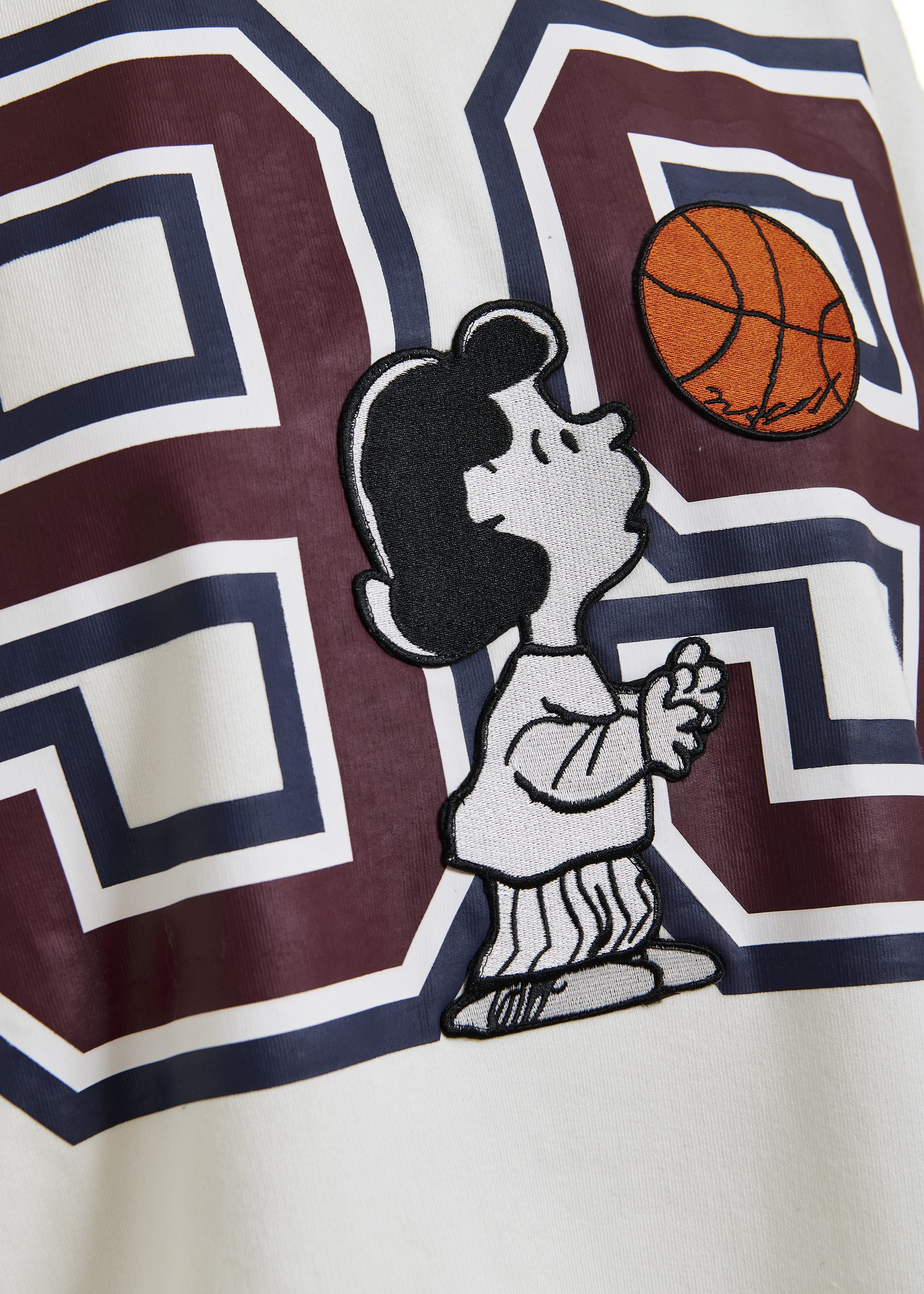 Off-white T-shirt with appliquéd Peanuts™ Lucy patch and text