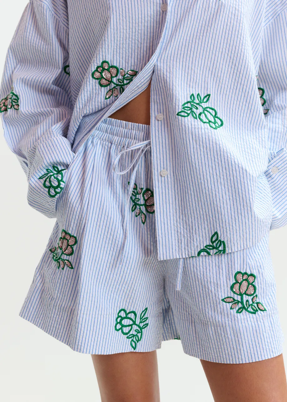 Gebroken wit shortje met lichtblauwe krijtstreep en kralen