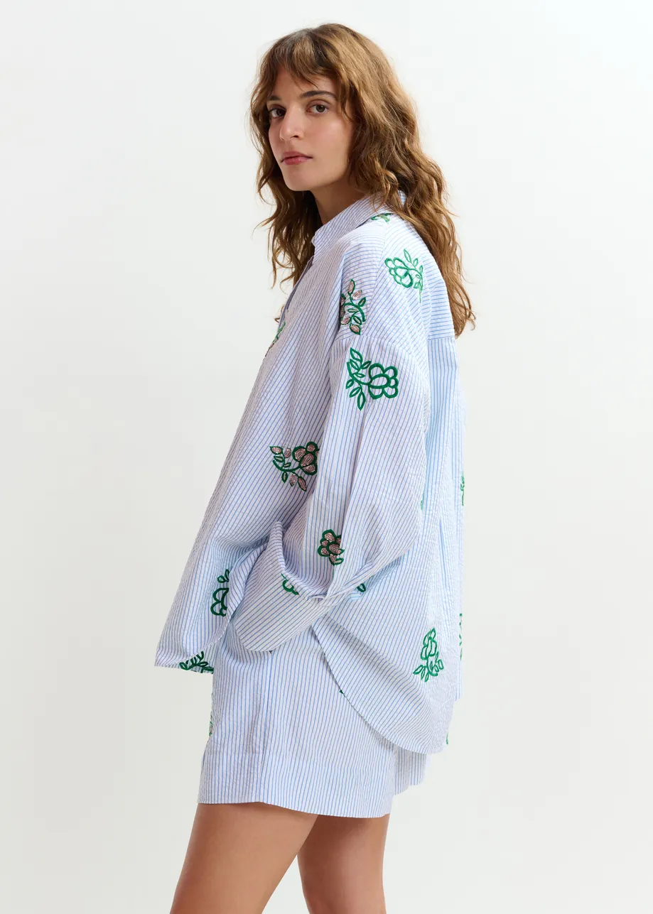 Gebroken wit shortje met lichtblauwe krijtstreep en kralen