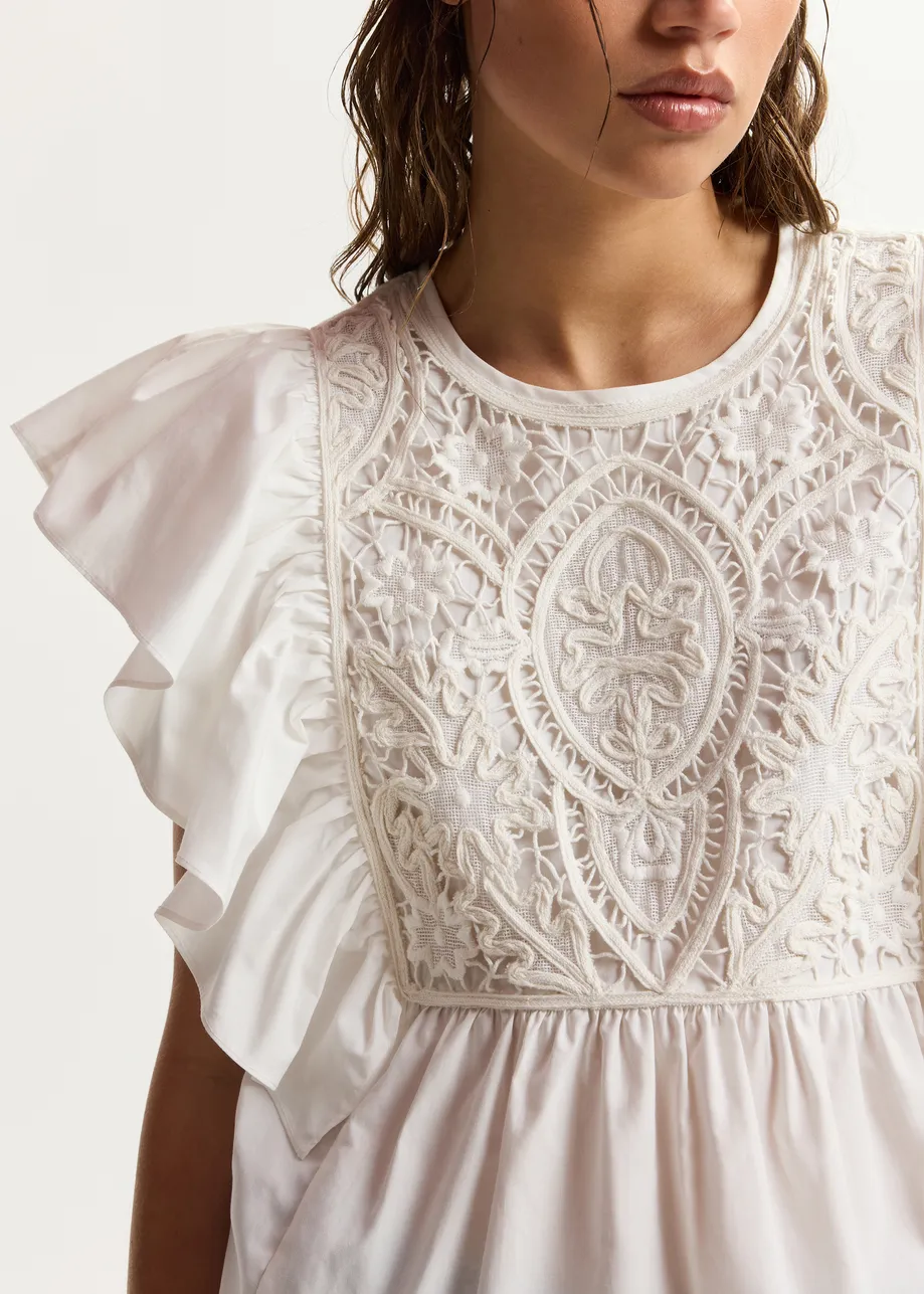 White cotton peplum top with lace-embroidered front and ruffled sleeves