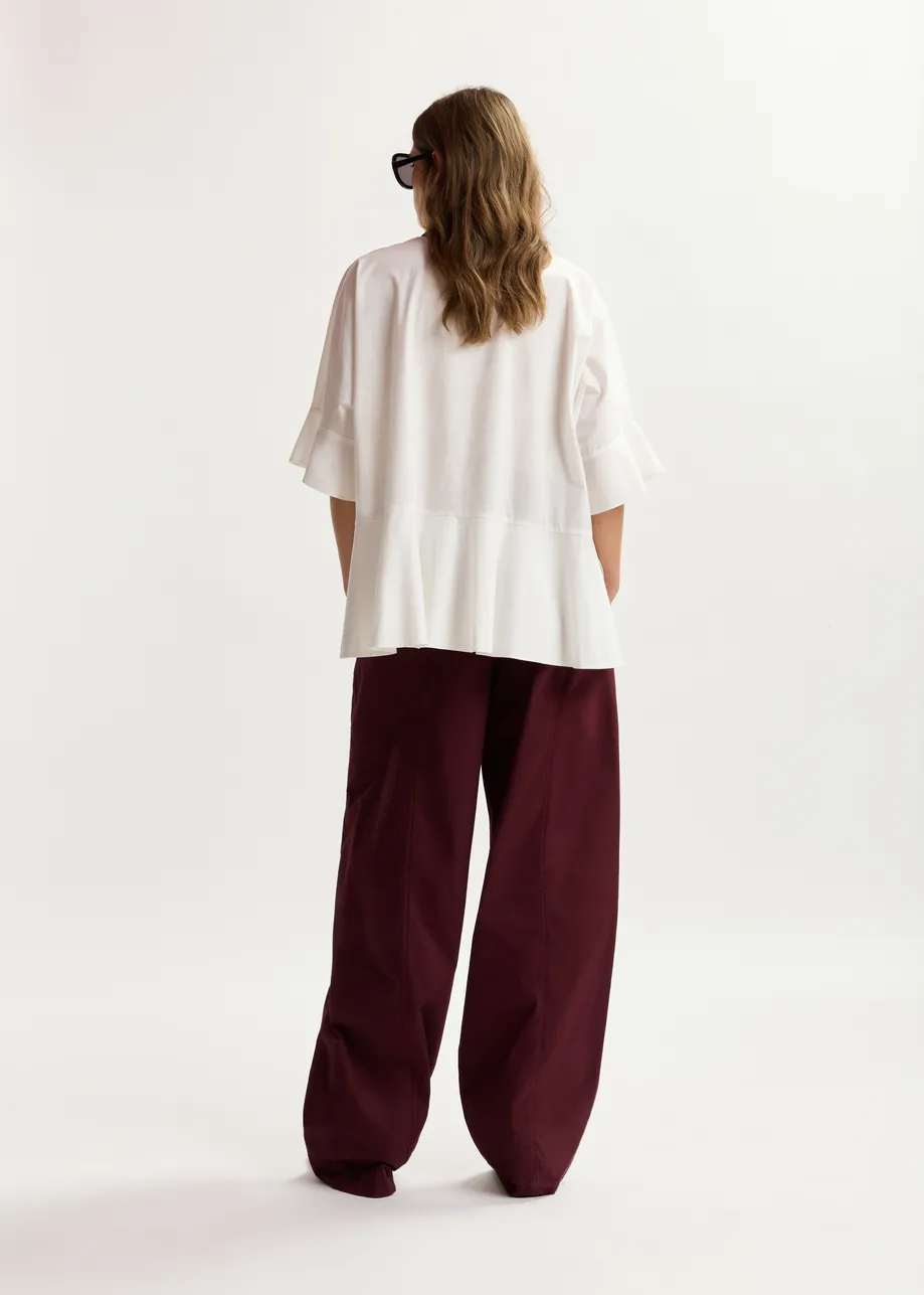 Dark red tapered cotton pants with twisted seams