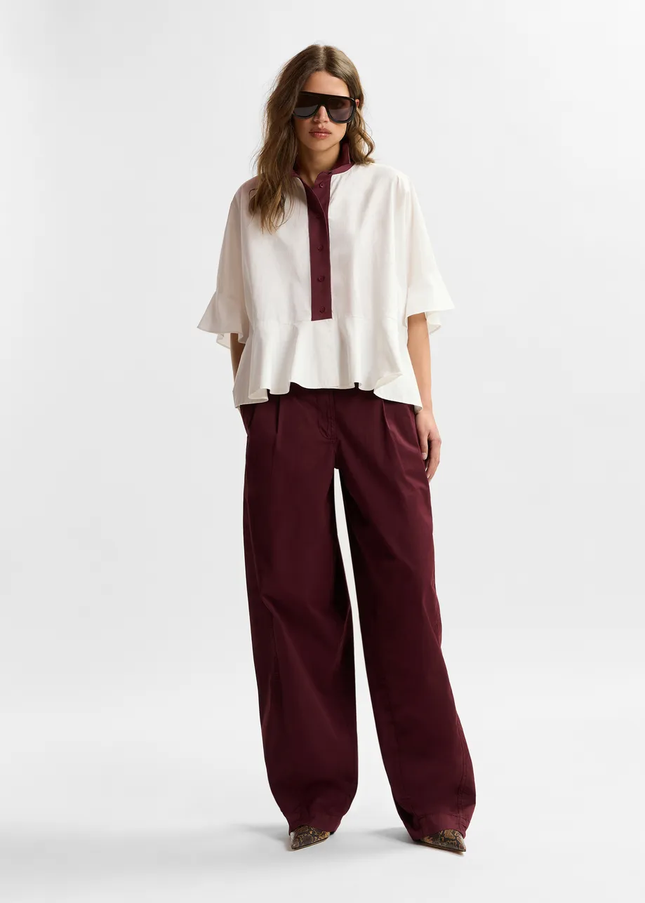 Dark red tapered cotton pants with twisted seams